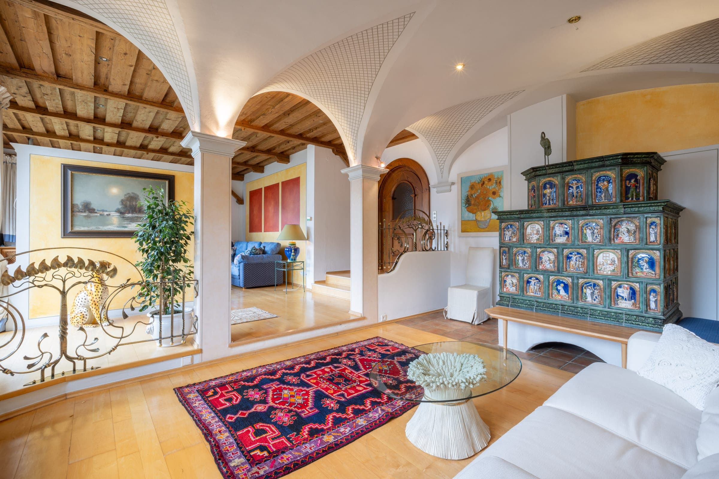 Wohnzimmer der Villa Emma mit Gewölbebögen, Holzdecke und Kachelofen
